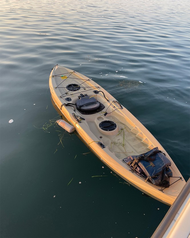 photo of open tan kayak floating on lake