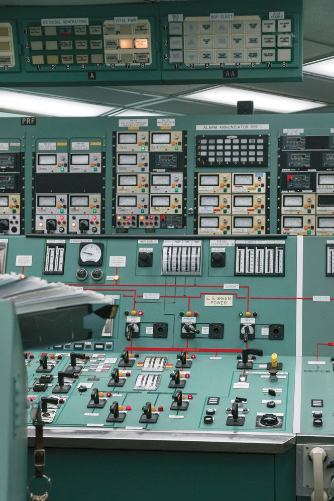 photo of very large vintage-looking green control board with dozens of dials, switches, and lights