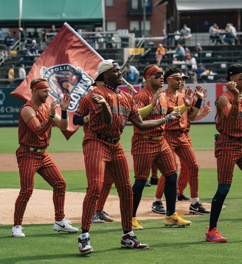 photo of uniformed players doing dance moves while one waves a flag