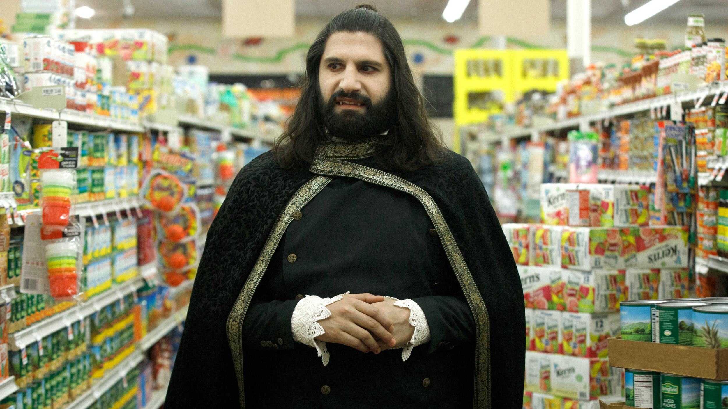 Kayvan Novak stands in a grocery-store aisle, in 