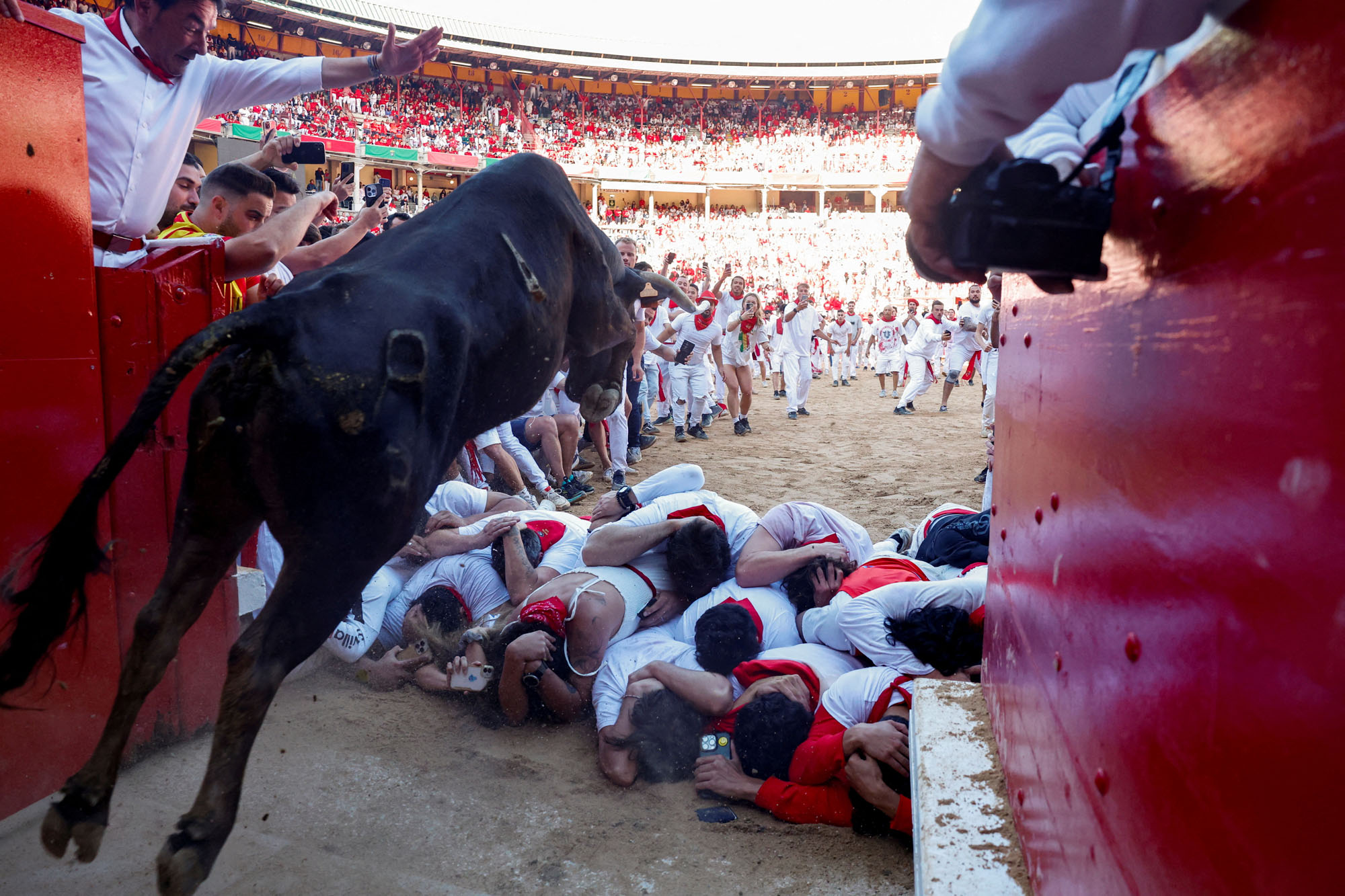 Revelers brace themselves as a steer jumps over them at the San Fermin festival in Pamplona, Spain