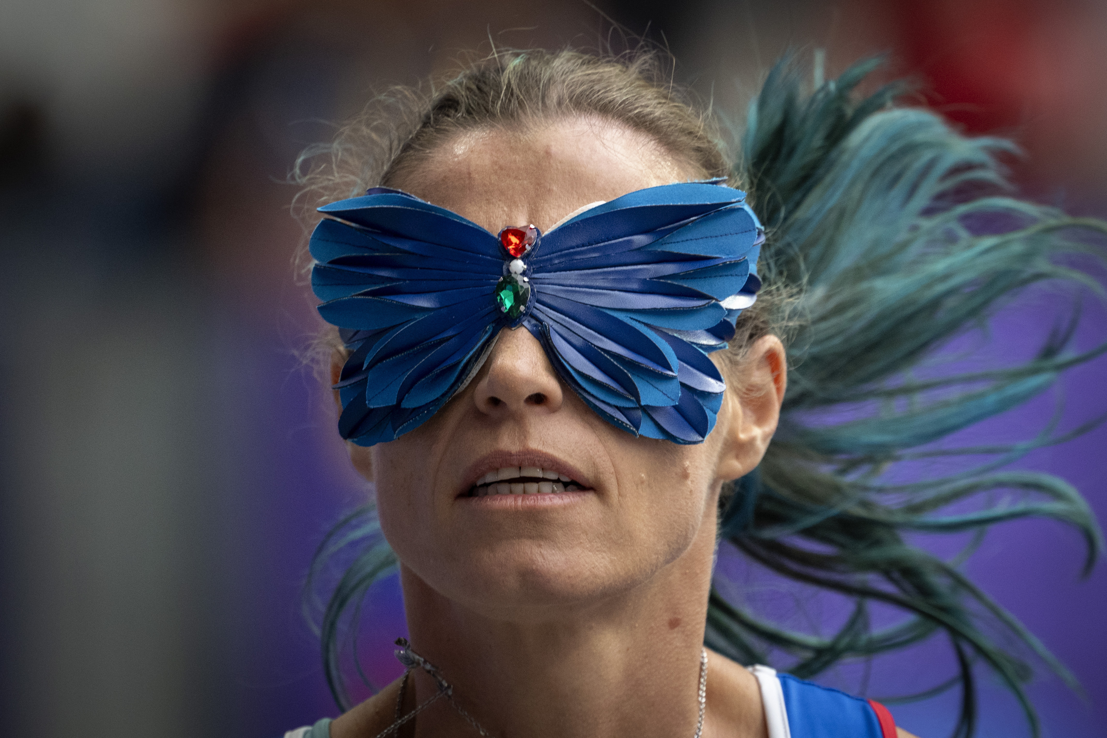 A Paralympic athlete runs with a butterfly blindfold on