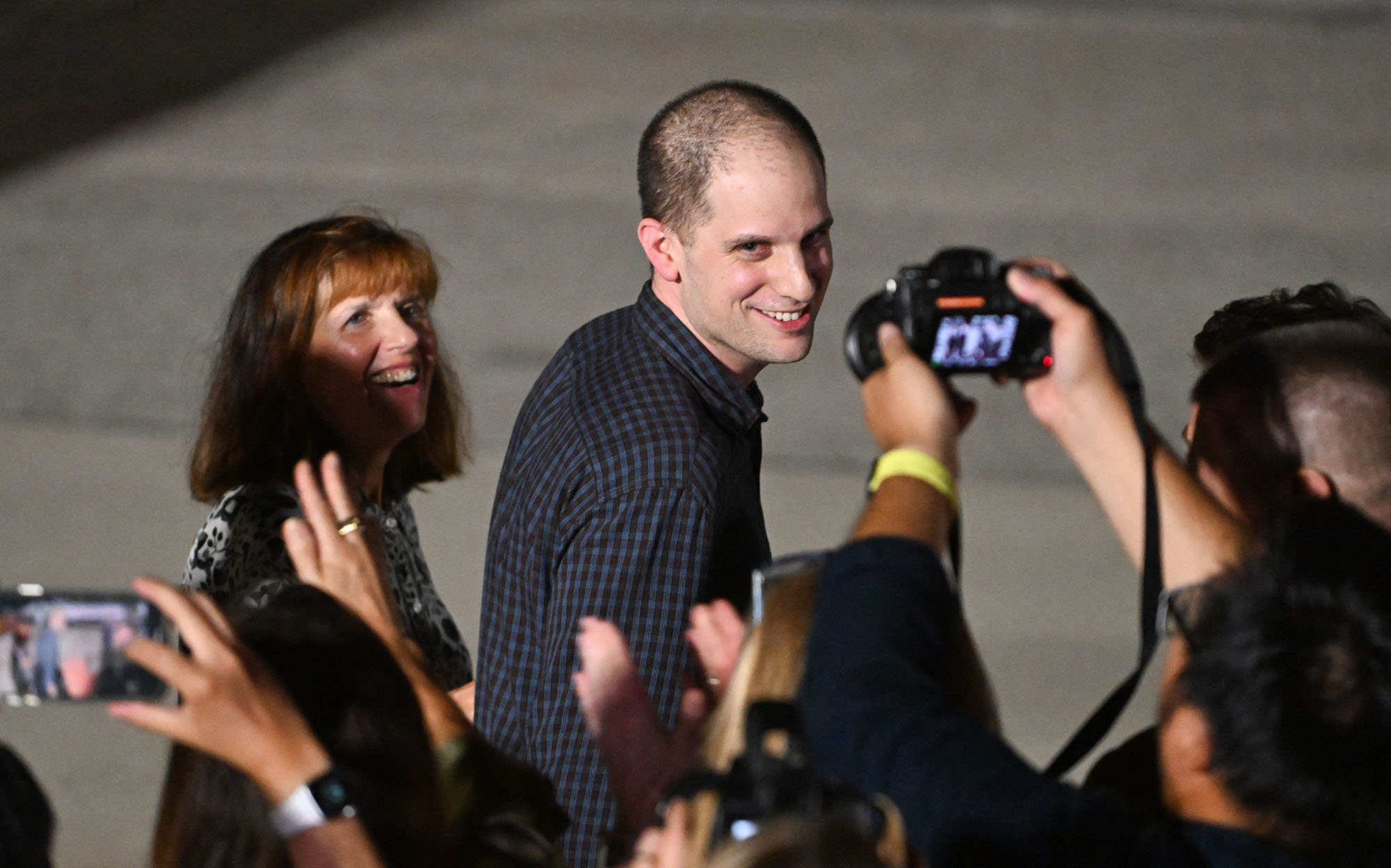 The journalist Evan Gershkovich, followed by his mother, Ella Milman, smiles as he arrives in Maryland after being released from Russian prison.