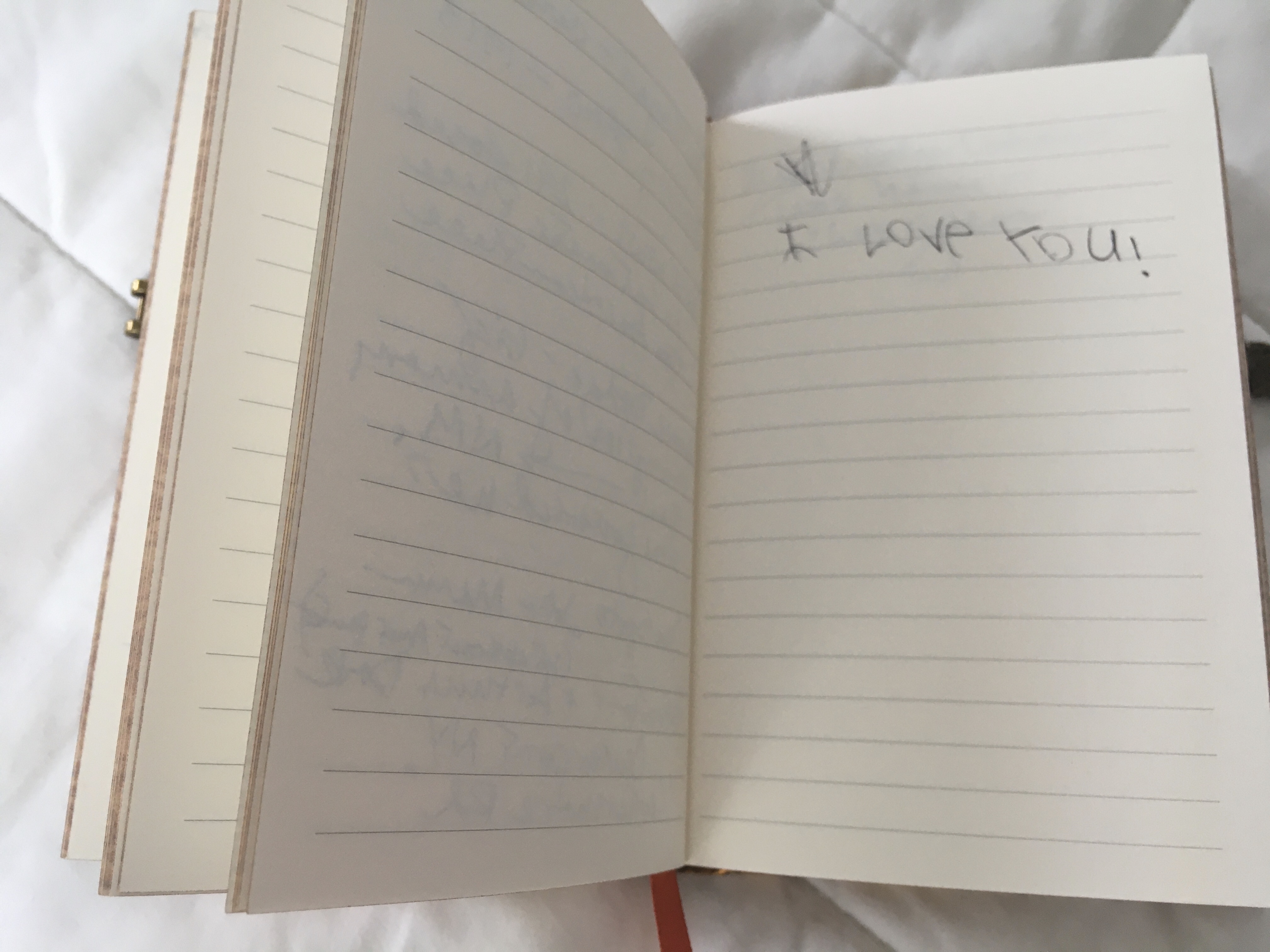 A notebook with "I love you" scrawled in a child's handwriting