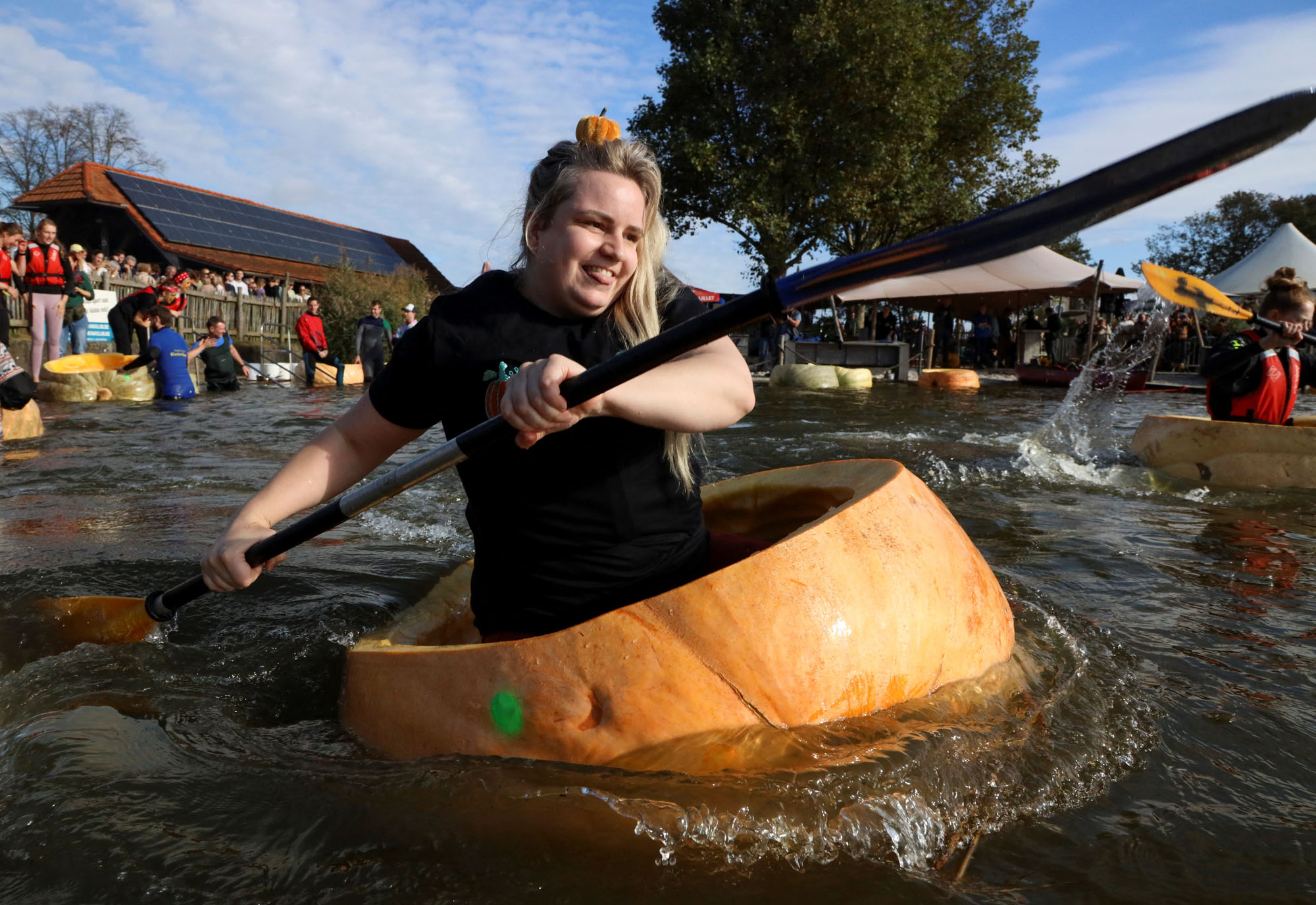 A competitor paddles in a giant hollowed-out pumpkin at the yearly pumpkin regatta in Belgium.