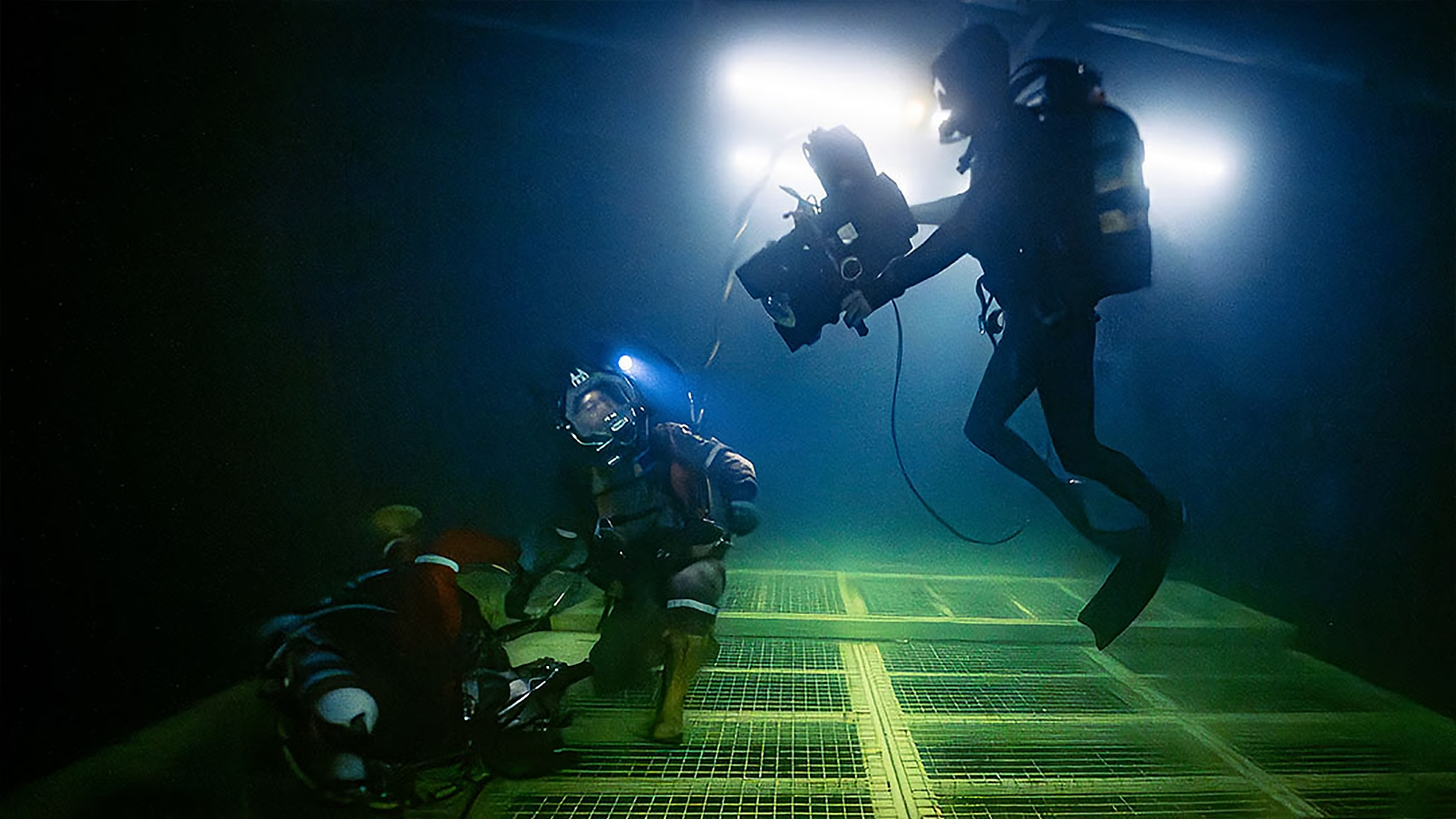 Three deep sea divers swimming in the ocean