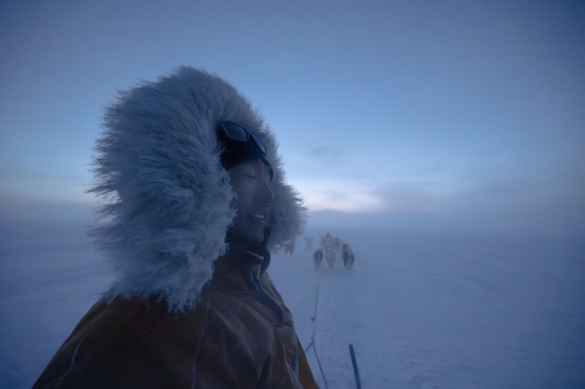 The Inuit professional bear hunter Martin Madsen, 28, closes his eyes as he rides his dog sled over very soft snow in the village of Ittoqqortoormiit in Greenland.