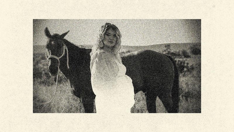 Grainy black-and-white photo of Taylor Parker looking pregnant with a horse in background.