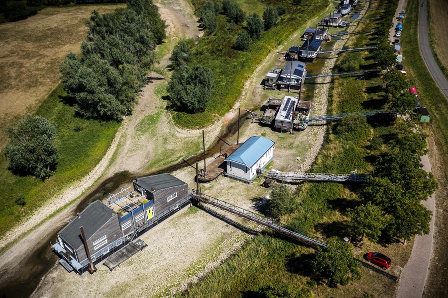 An aerial view of several houseboats resting on a dry riverbed