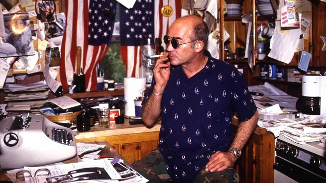 Hunter S. Thompson sits in front of a typewriter