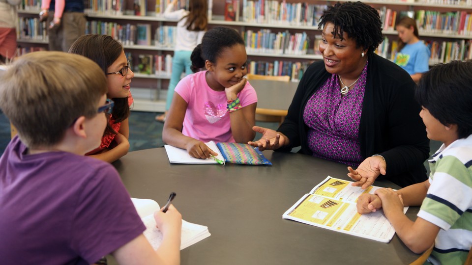 Stacey Abrams speaks with a group of children