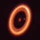 The exoplanet PDS 70c seen as a speck of light within a bright circle, surrounded by a circumplanetary disk
