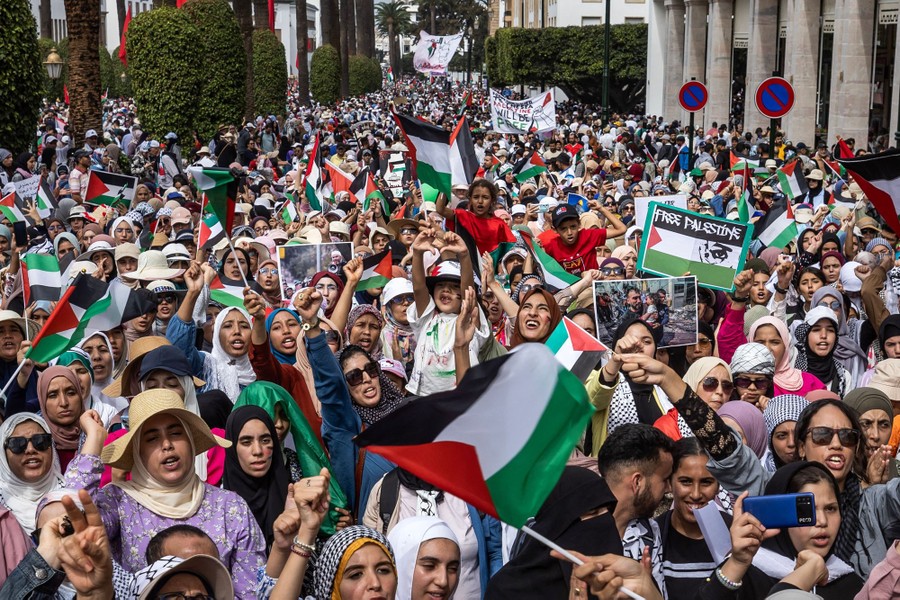 A large crowd of pro-Palestinian protesters gathers in a street.