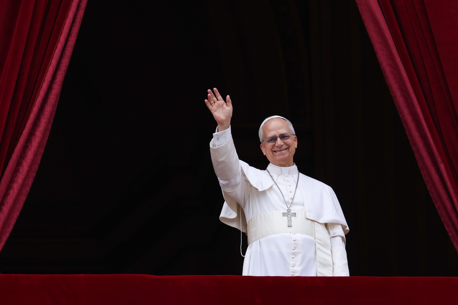 Pope Leo waves from a balcony.