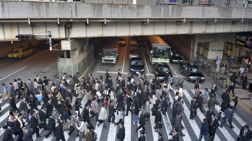 Workers cross the street in Osaka, Japan.