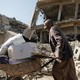 A man walks past a house destroyed during fighting between Iraqi security forces and Islamic State's fighters in Mosul, Iraq, carrying a wheelbarrow loaded with possessions. 