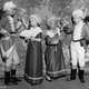 Children in colonial-era costumes on a theater stage.