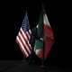 A man on a black stage removing the Iranian flag
