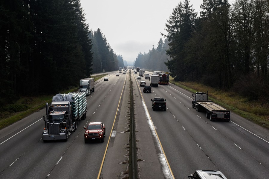 A view of a six-lane highway among pine trees.
