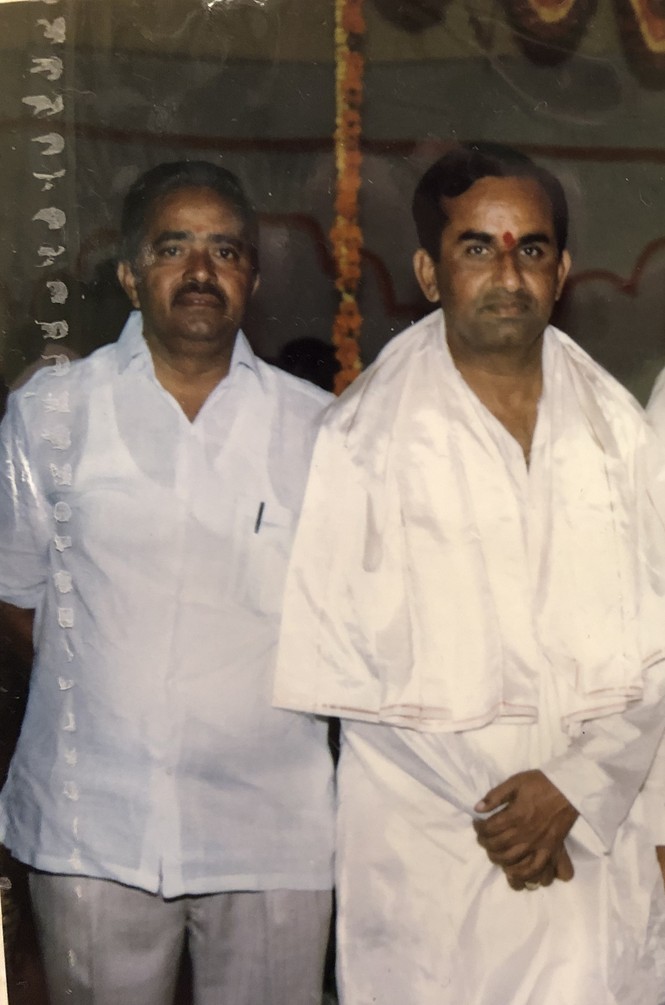 Two men dressed in white pose unsmiling for the camera