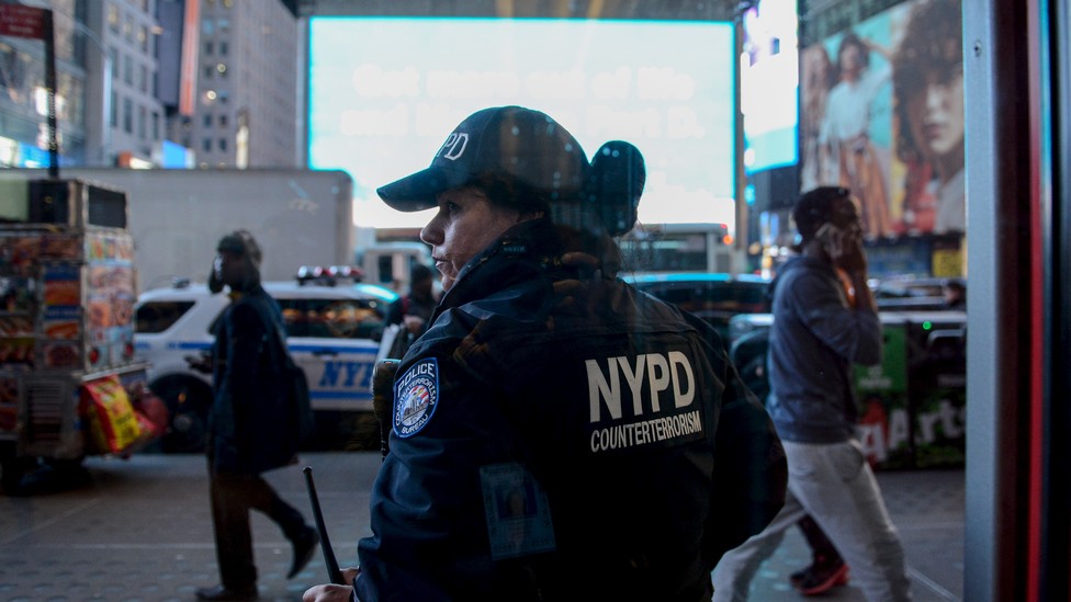 A NYPD counter-terrorism officer is seen through a window in New York City.