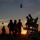 Kids are seen in silhouette at sunset on the beach in Atlantic Beach, New York, on September 6, 2015.