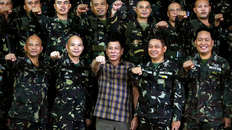 Philippine President Rodrigo Duterte makes a "fist bump", his May presidential elections campaign gesture, with soldiers during a visit at Capinpin military camp in Tanay, Rizal in the Philippines August 24, 2016.
