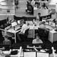A black-and-white photograph of employees working in the Washington Post newsroom