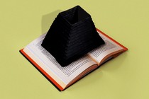 A book with the opening to a black hole emerging from its center