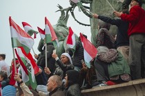 A crowd of young people at a Peter Magyar rally holding Hungarian flags