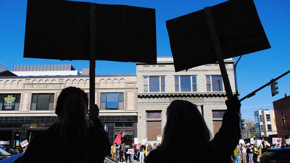 people holding signs at no kings protest
