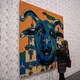 A person takes a photo of a Lego portrait of a bull.