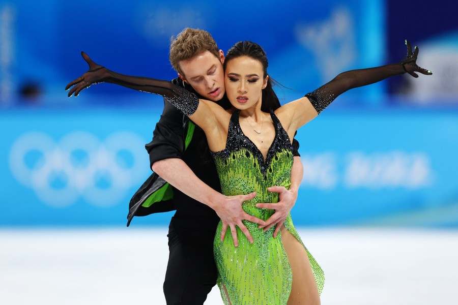 A pair of figure skaters perform, holding each other close.