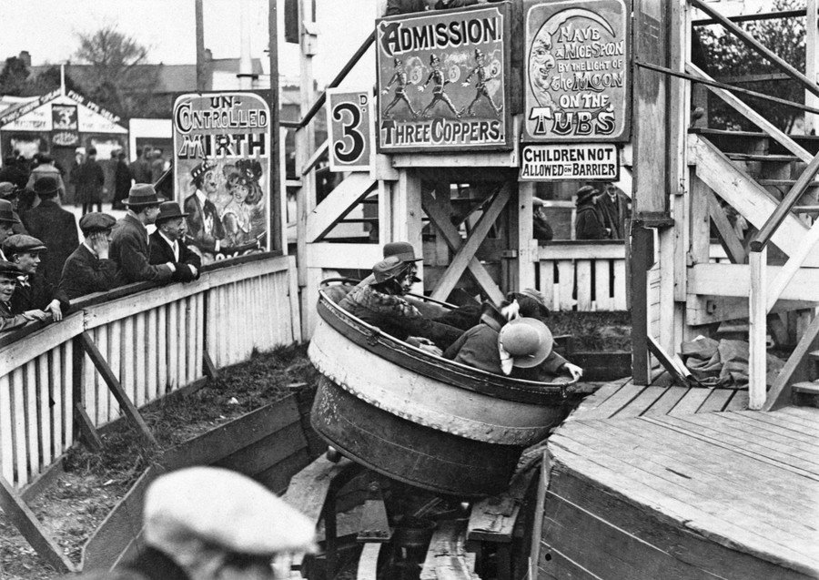 People enjoy fairground rides while others watch.