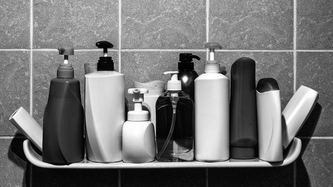 Row of generic plastic bottles in a bathroom.