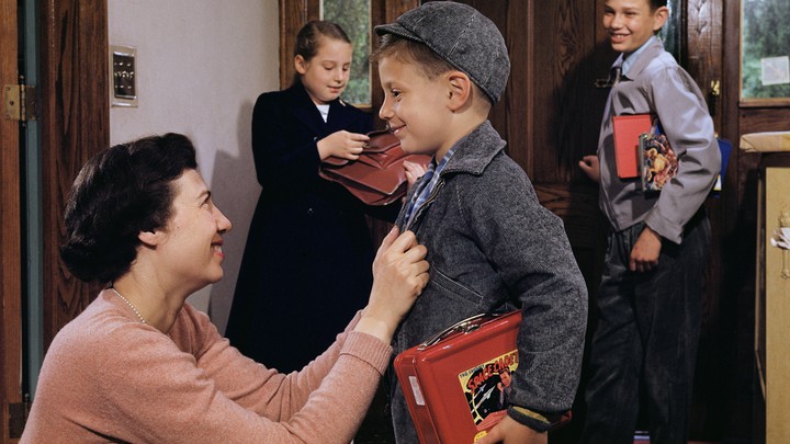 A mother sending children off to school