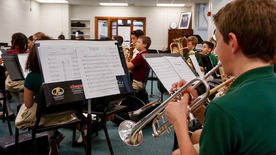 Students play band instruments including trumpets, tubas, and French horns.
