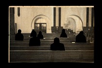 silhouettes of figures sitting in pews