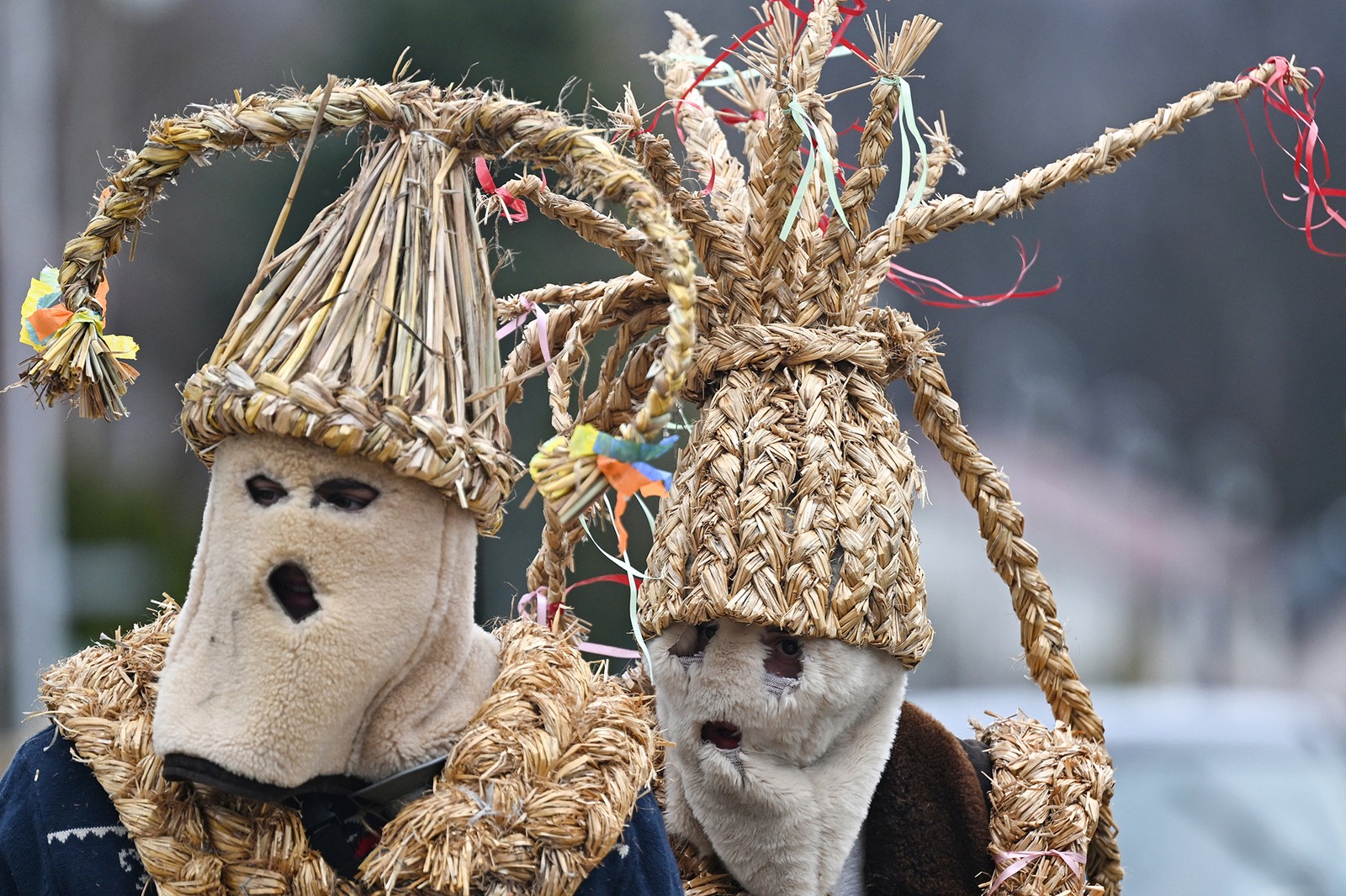 Two men wear traditional straw costumes during a fertility festival in Poland.