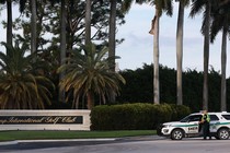 A sheriff's deputy stands outside Trump International Golf Club