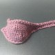 A pink knitted object resembling a ladle
