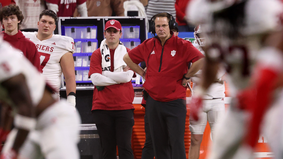 An image of Indiana Hoosiers Coach Curt Cignetti scowling from the sidelines.