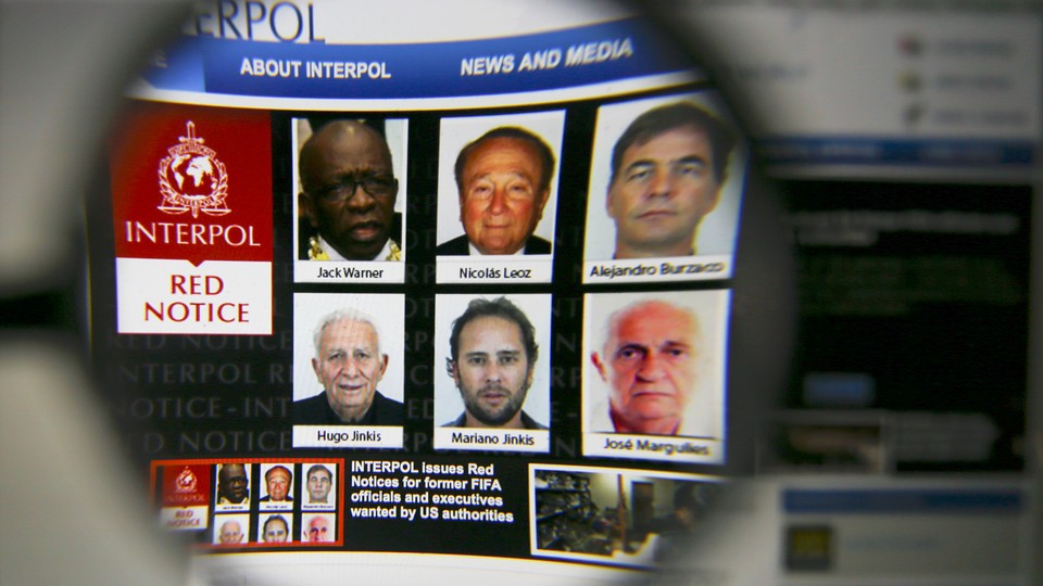 The homepage of the Interpol website is seen through a magnifying glass in this picture illustration taken in 2015.