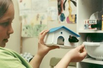 Elaine Godfrey as a child, holding a small plastic house with a rat inside it