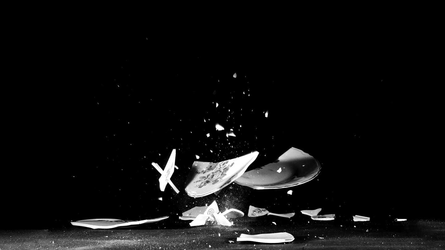 a white plate shattering on a black background