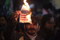 An Iranian protester burns the U.S. flag