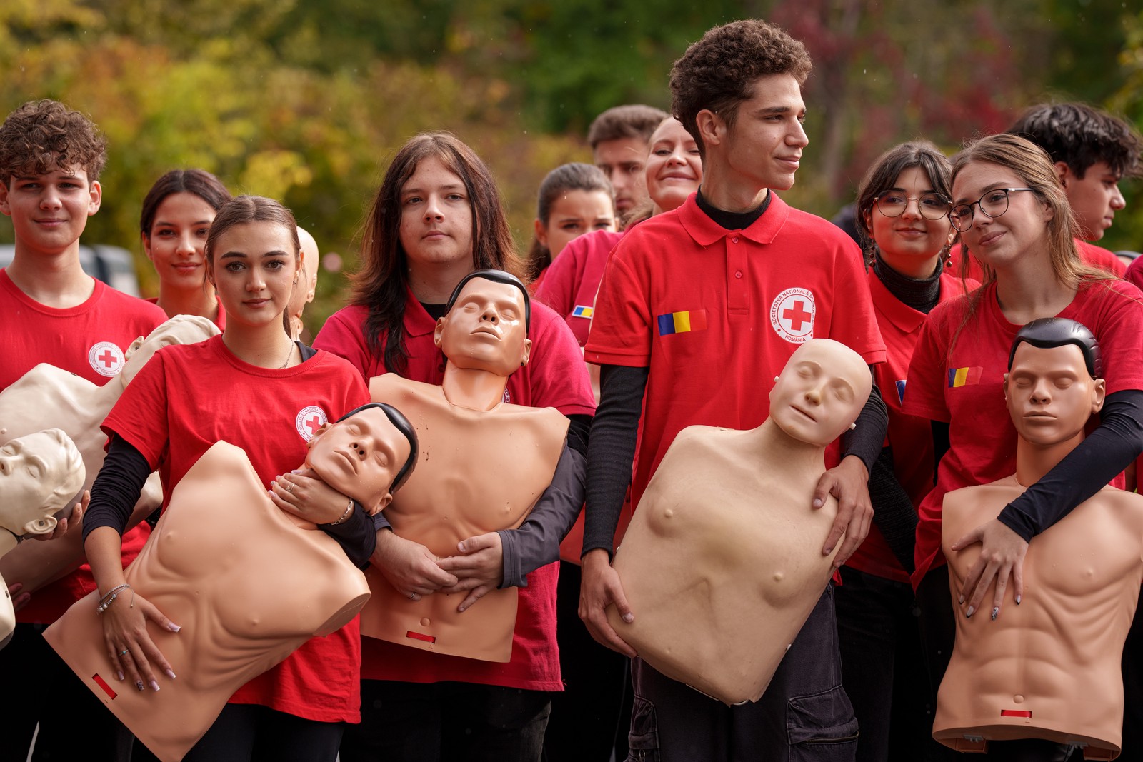 A group of young people hold CPR mannequins before a flash mob.