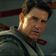 Tom Cruise staring intensely while standing in front of a plane in "Top Gun"
