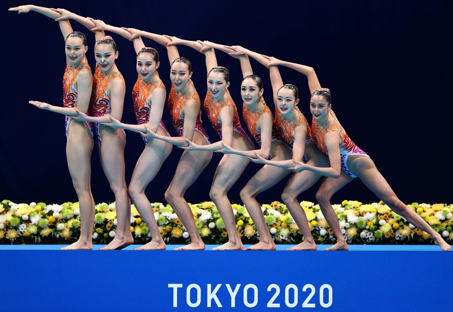 A team of artistic swimmers poses before their performance.