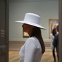 Melania Trump wears a white hat in the National Gallery of Art.